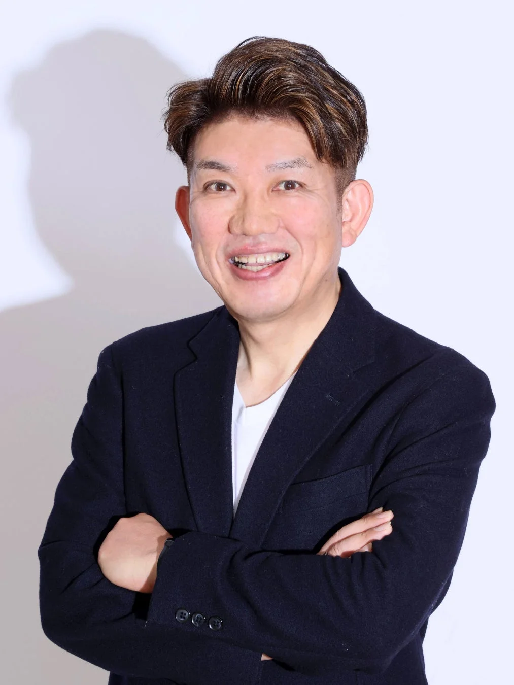 笑顔で腕組みをする男性のポートレート