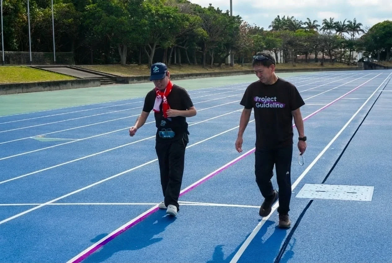 陸上競技場でProject Guidelineの活動に参加する人々