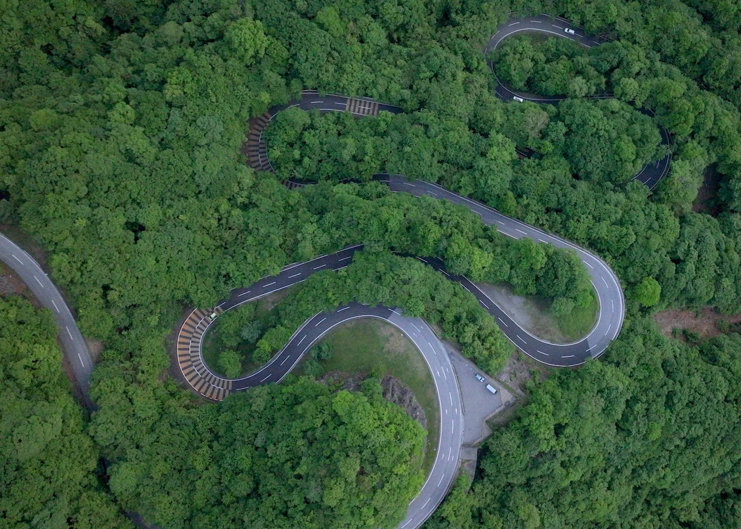 森林の中を蛇行するワインディングロード