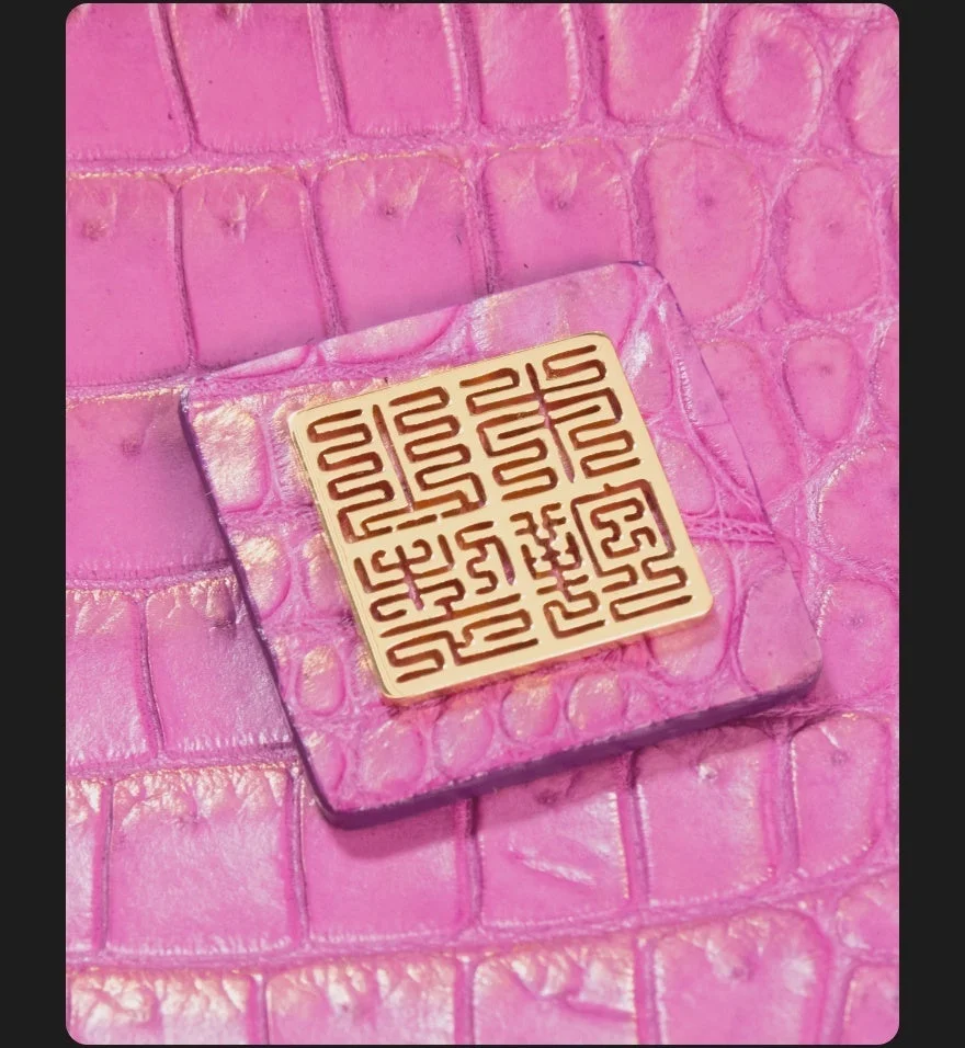 金色の装飾が施されたクロコダイル柄の革