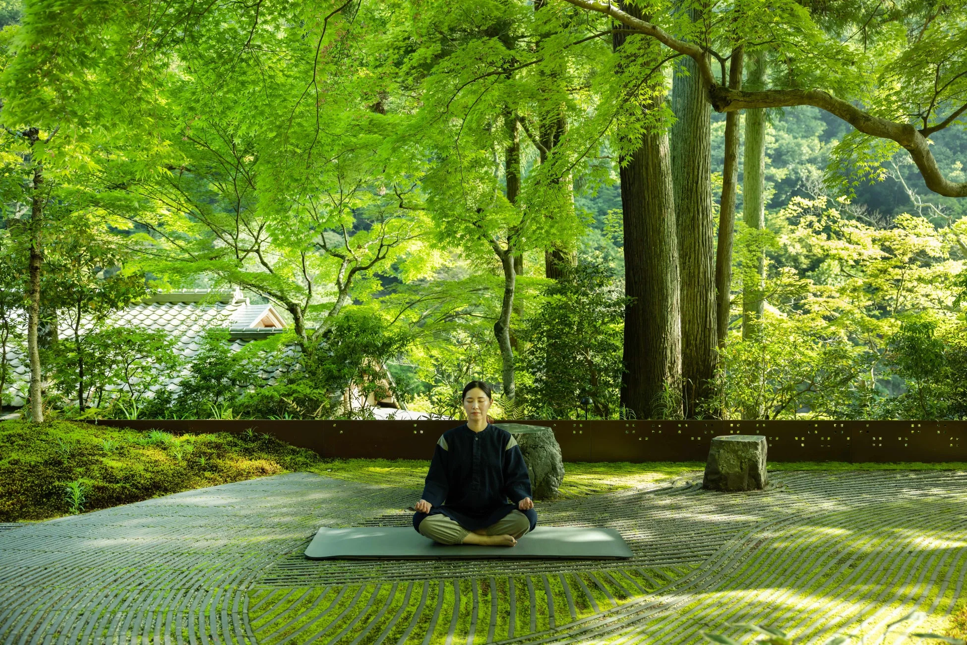 新緑の日本庭園で瞑想する女性