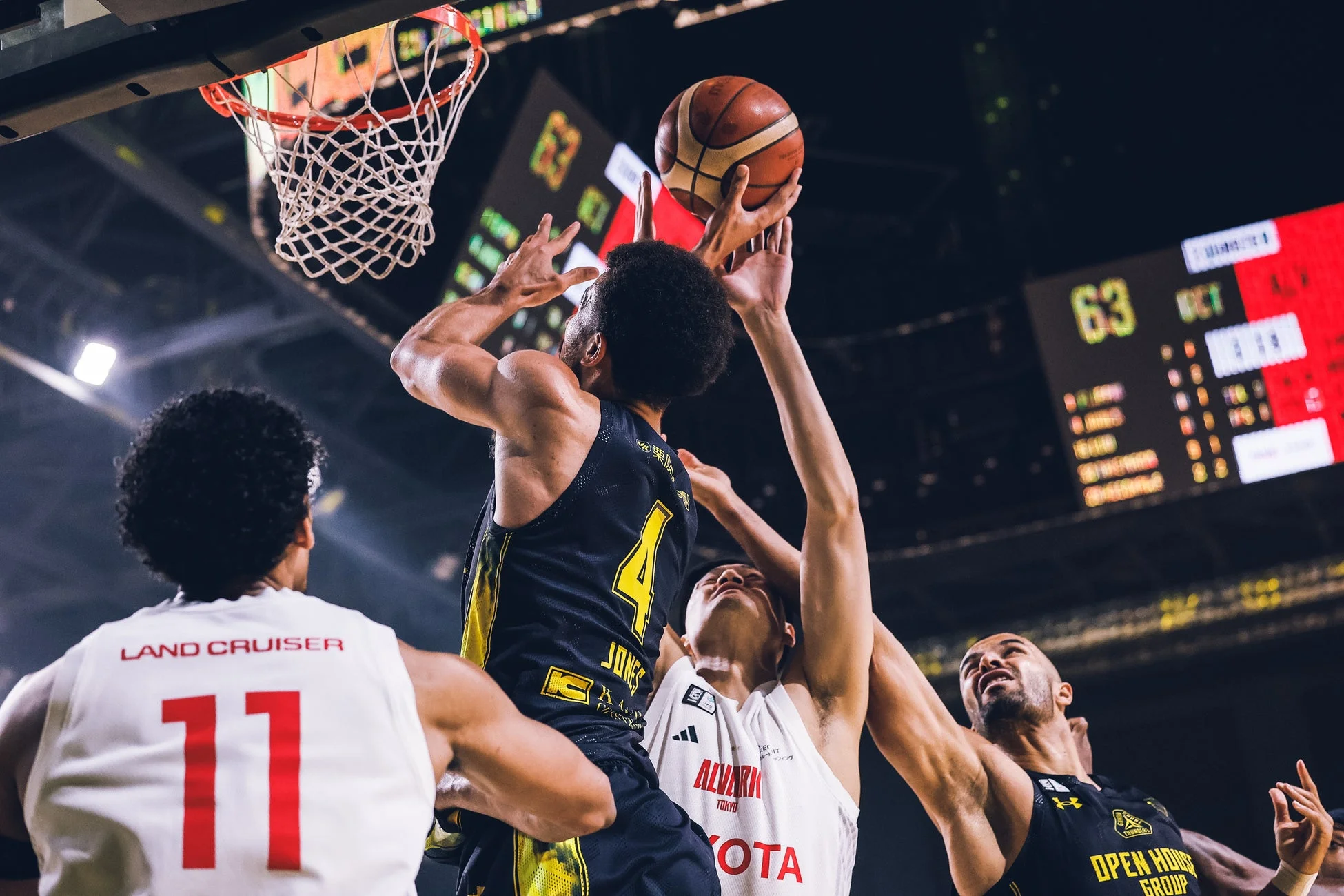 バスケットボールの試合中、激しくゴールを争う選手たち