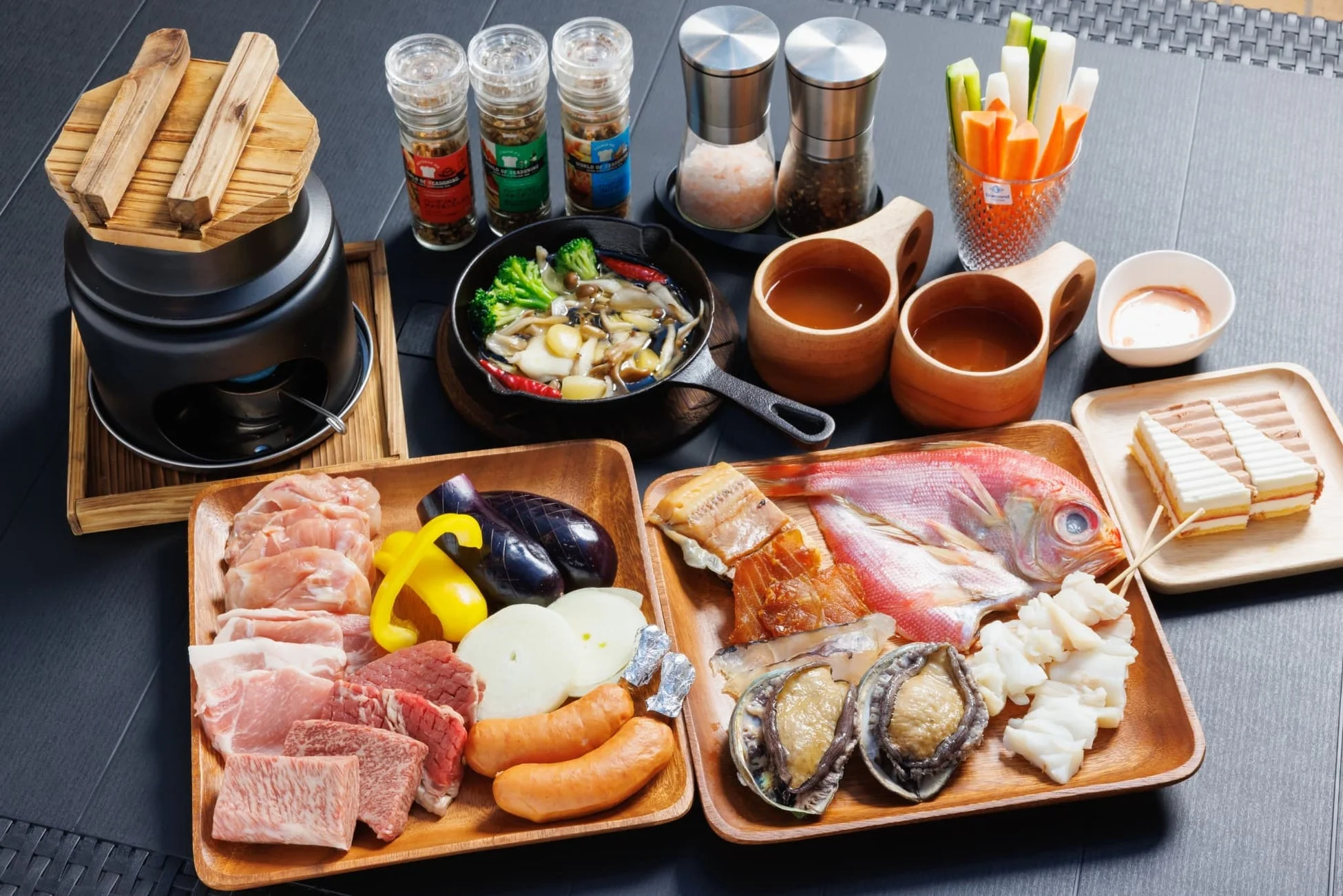 豪華な肉、魚介類、野菜が豊富に盛り付けられたバーベキューや鍋料理の準備風景