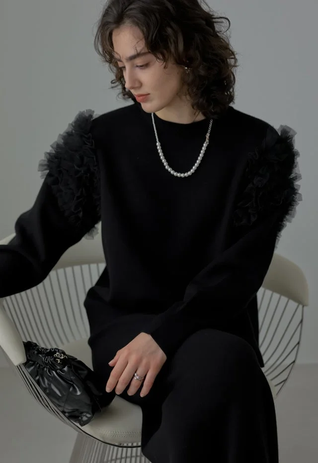 黒フリルスリーブトップスとパールネックレスのポートレート