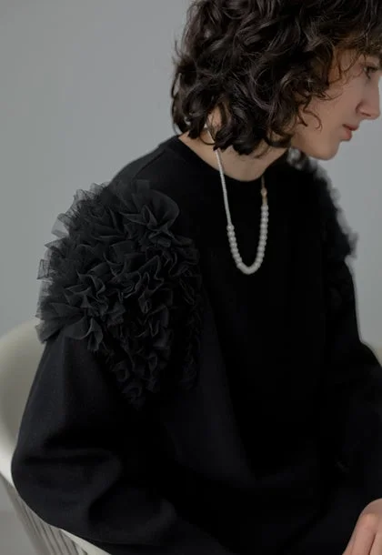 黒フリル付きトップスとパールネックレスのポートレート