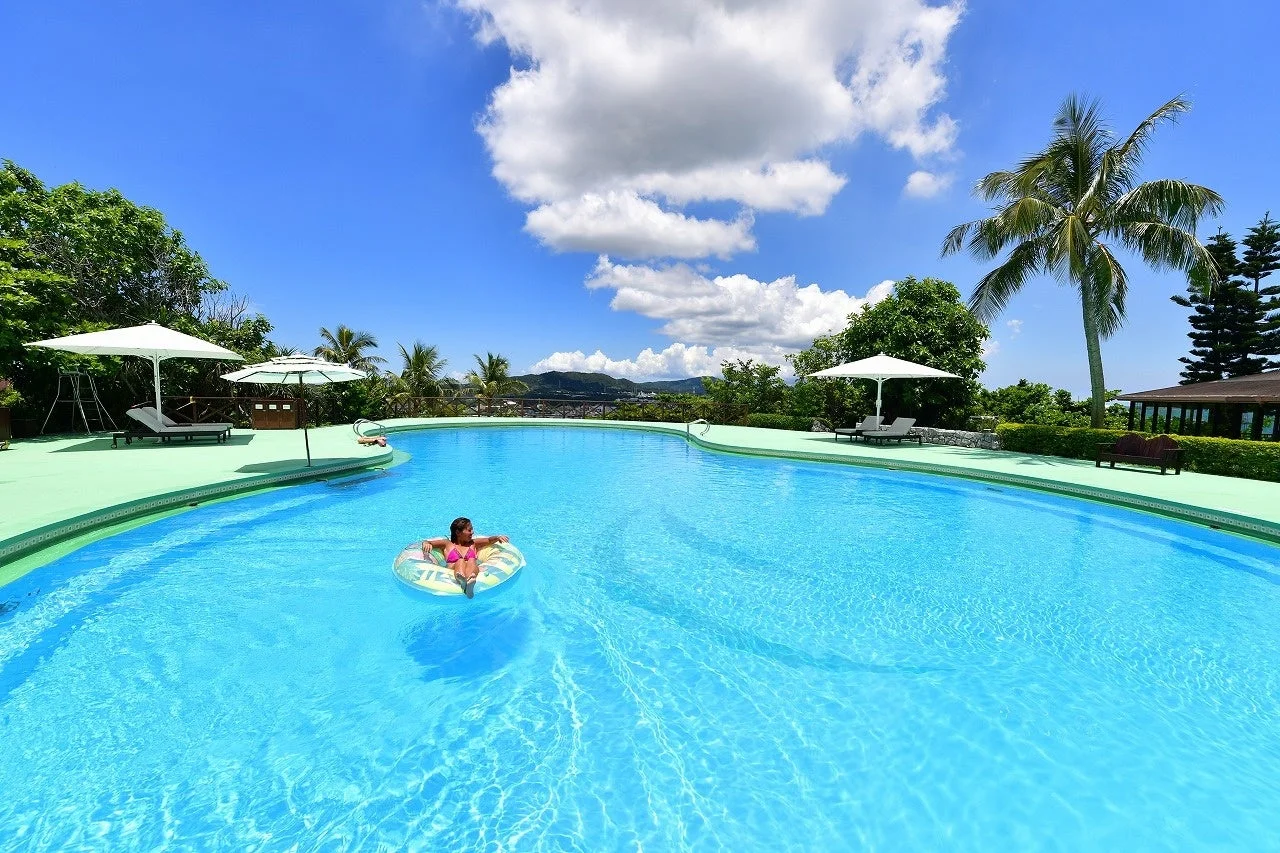 プールで浮き輪に乗る女性