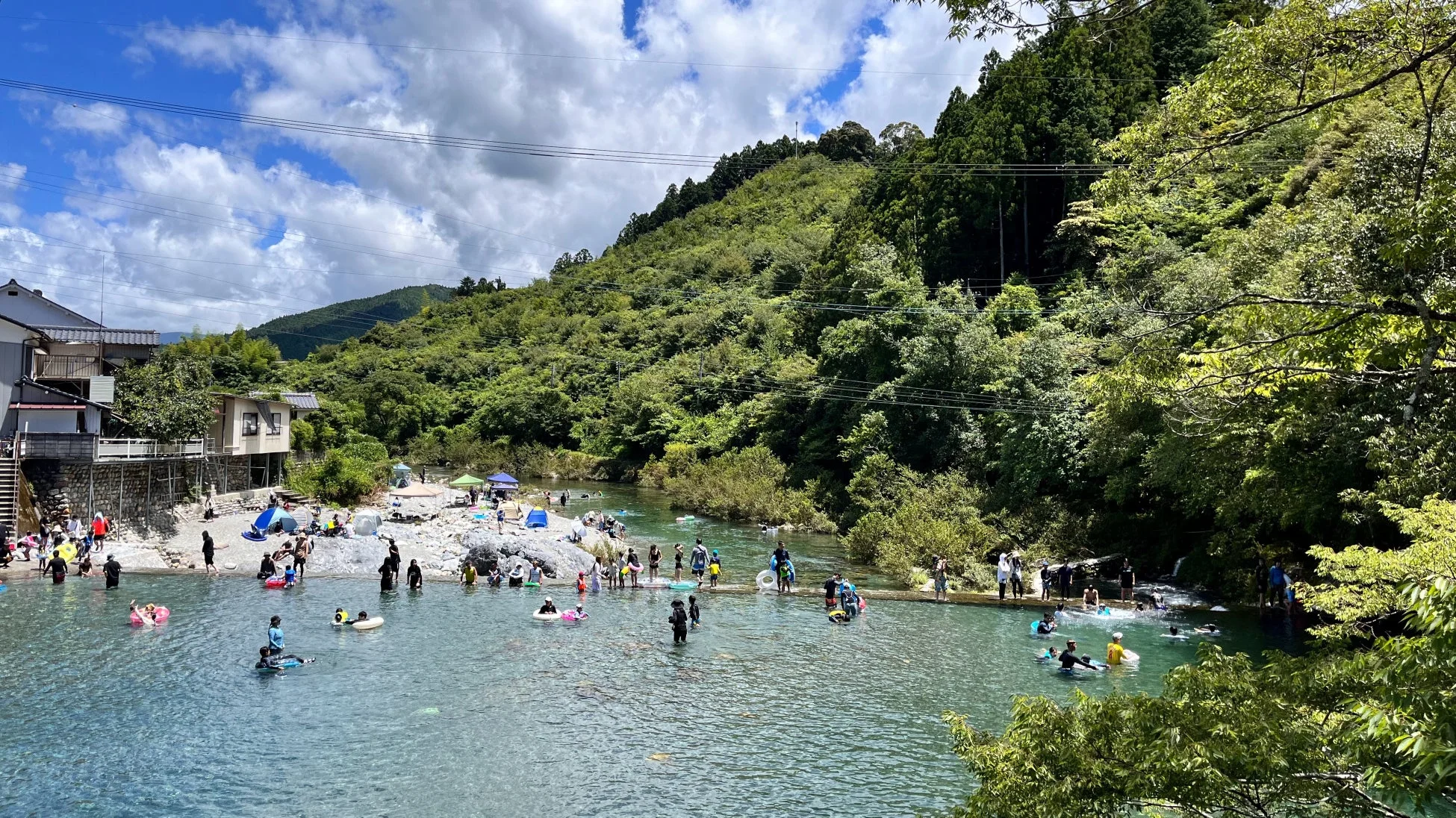川で水遊びを楽しむ人々