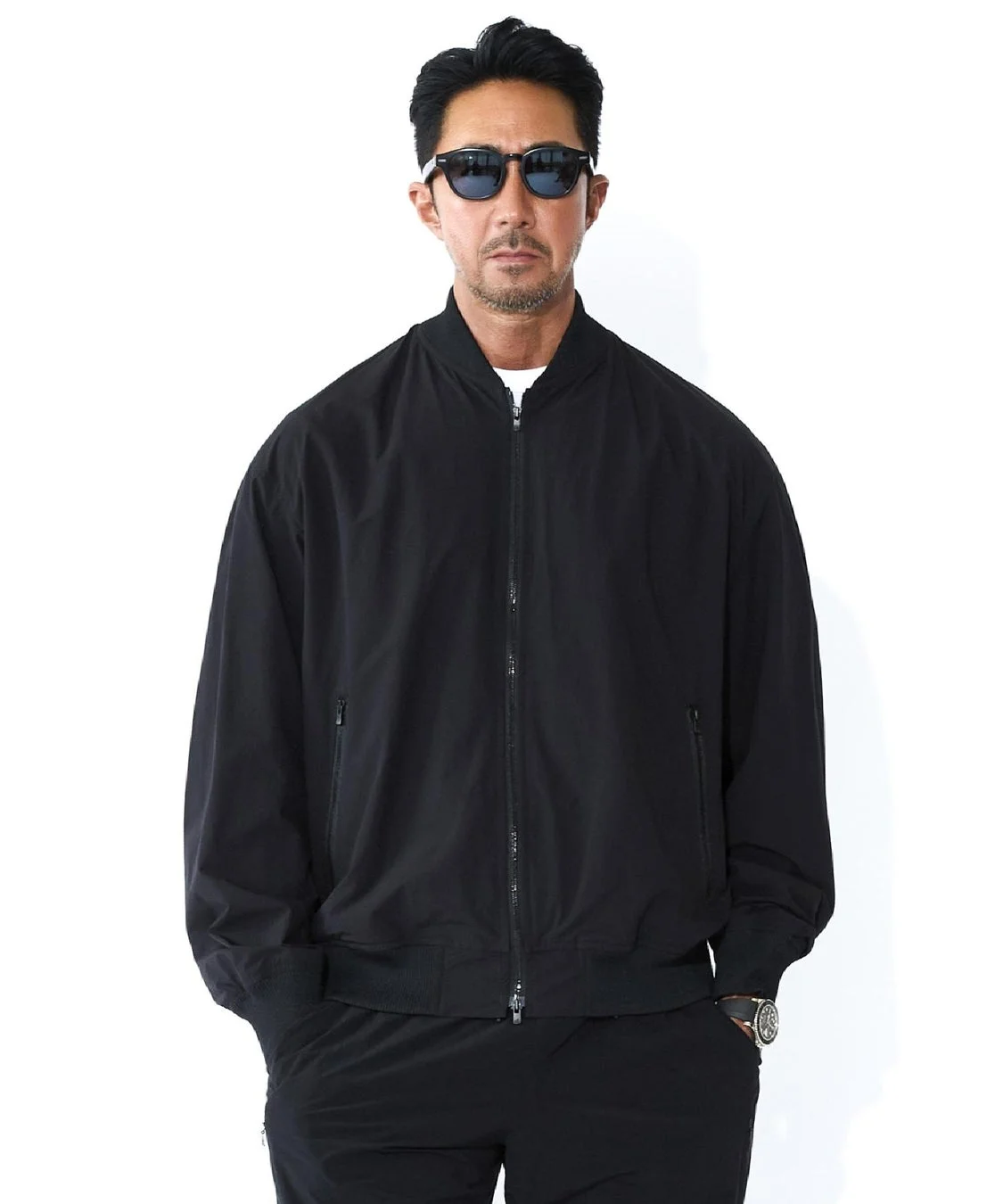 黒いボンバージャケットを着用した男性