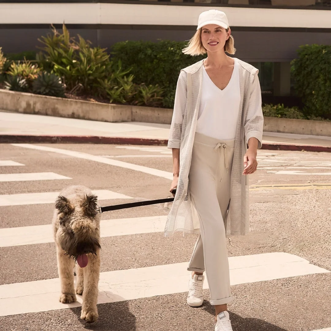 犬を連れて横断歩道を歩く女性