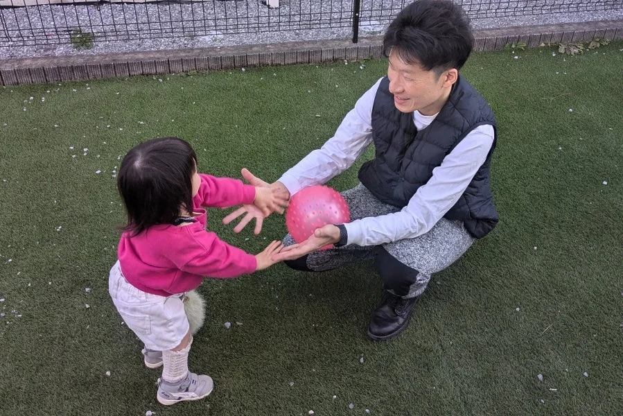 人工芝で遊ぶ親子