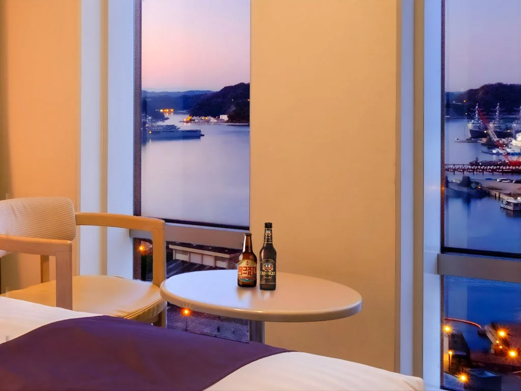 ホテルの客室で港の景色と共にビールを楽しむ様子