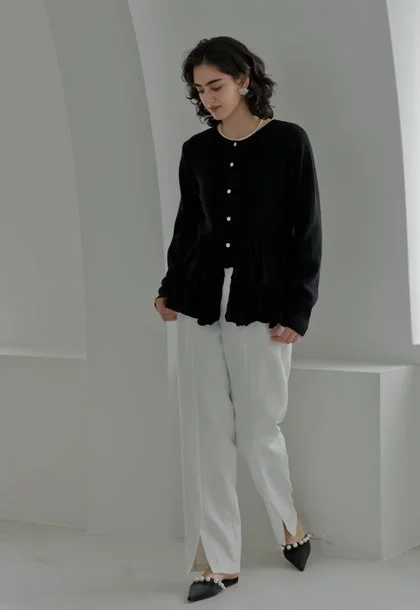 黒ペプラムカーディガンと白スリットワイドパンツのルック