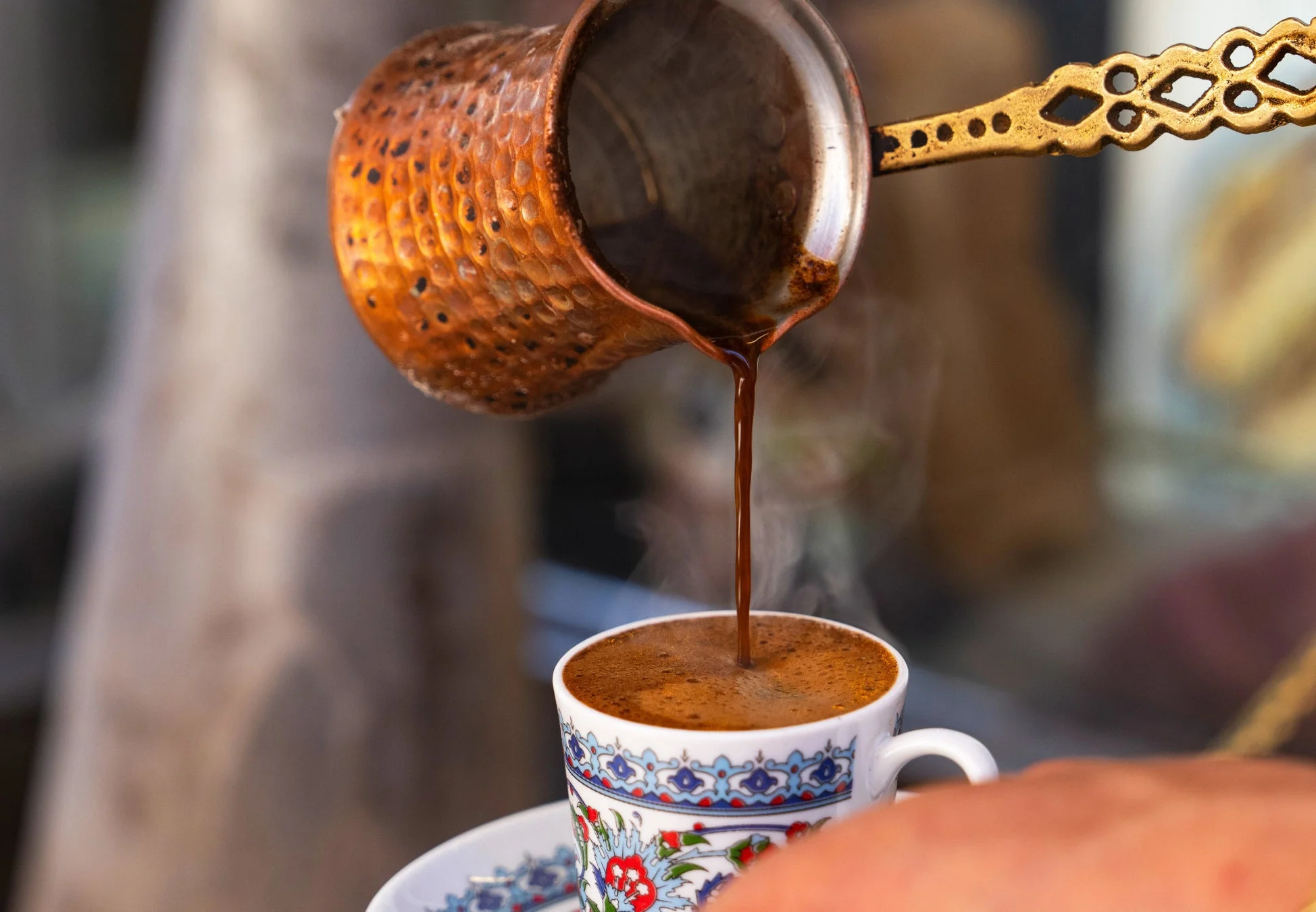 伝統的な銅製のポットからカップに注がれるトルココーヒー