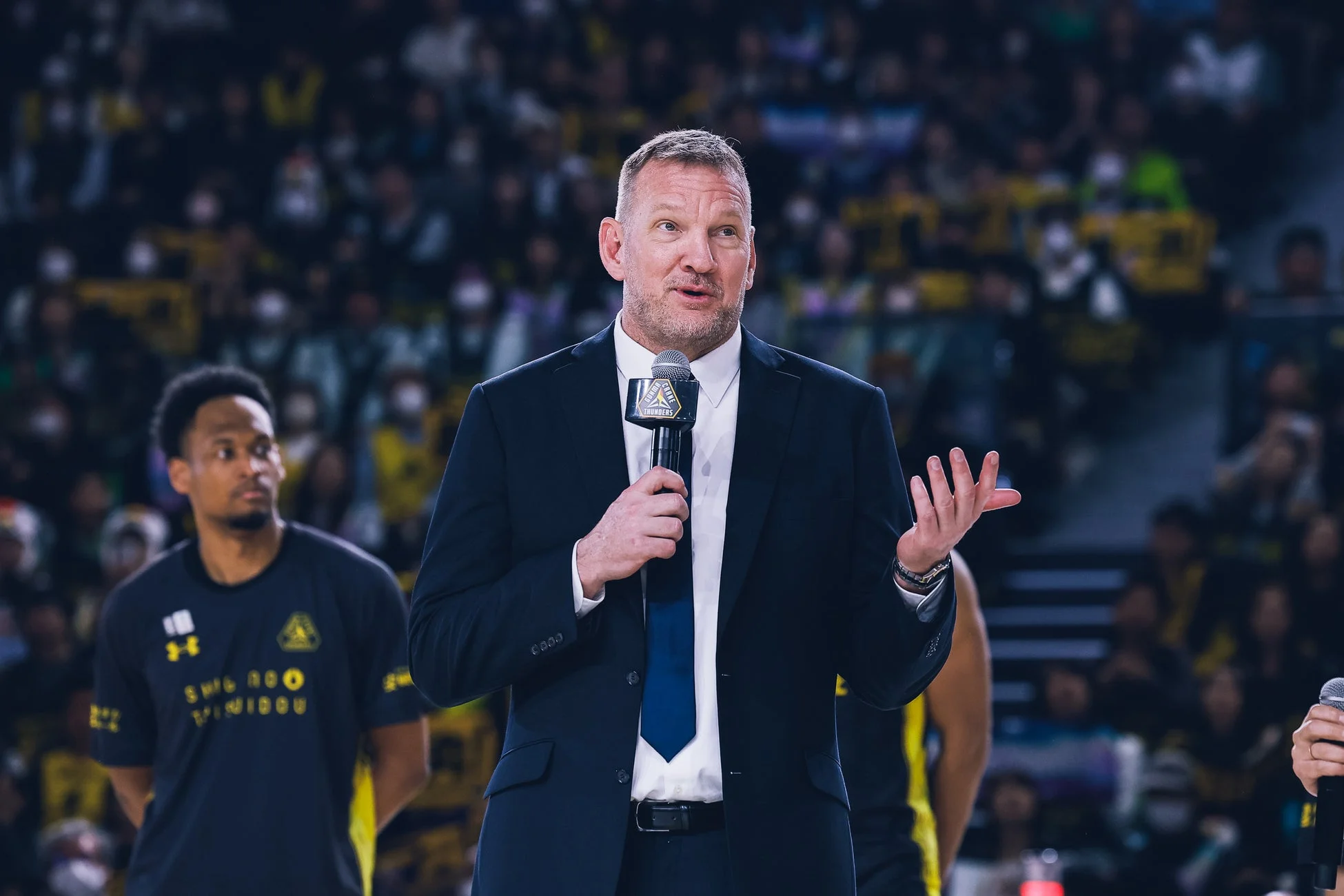 バスケットボールのアリーナでスピーチをする群馬クレインサンダーズのヘッドコーチ