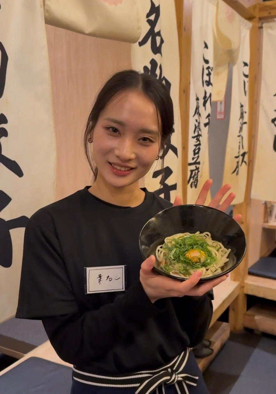 うどんを差し出す女性店員