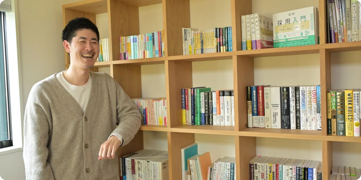 笑顔の男性と本棚