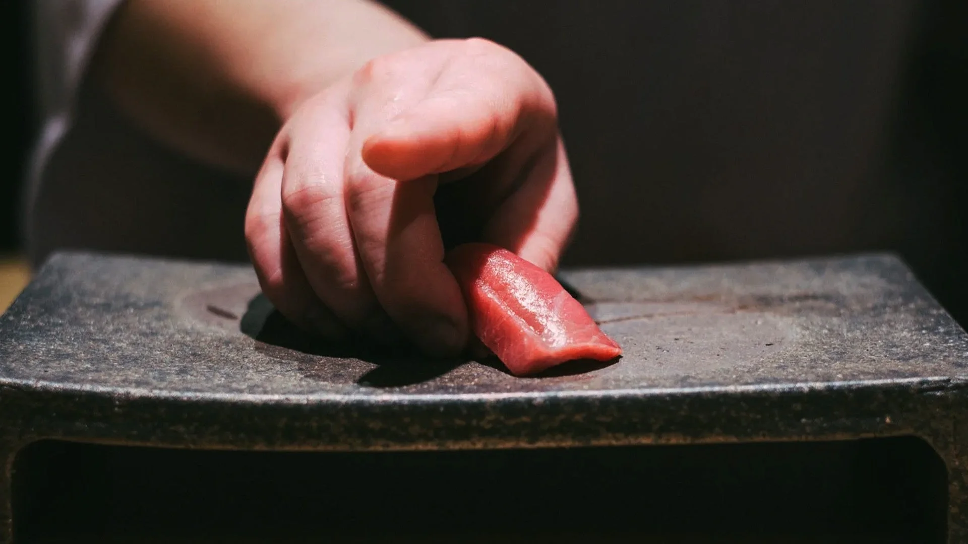 職人の手がマグロを握る様子