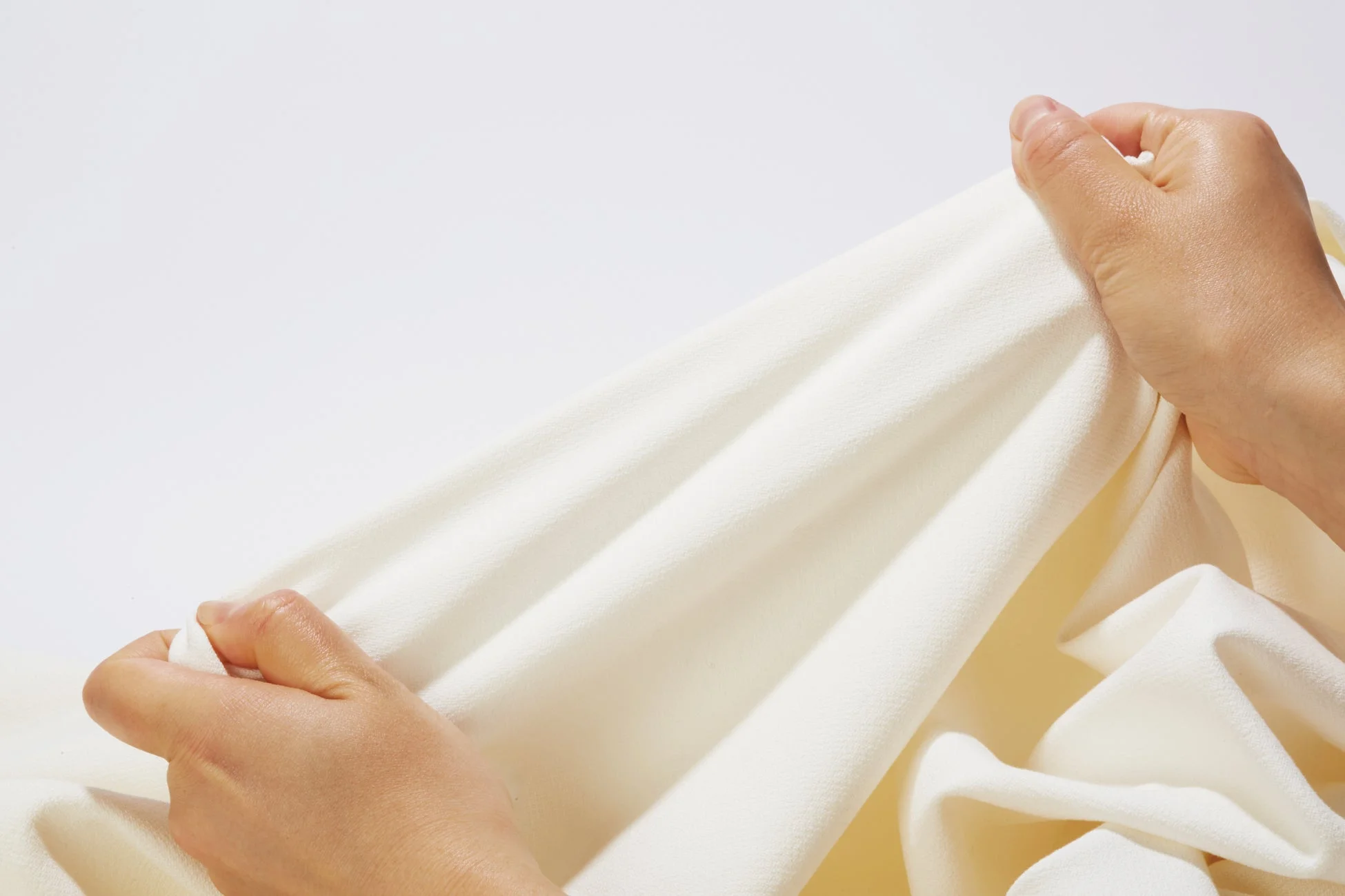 柔らかな布を引っ張る手