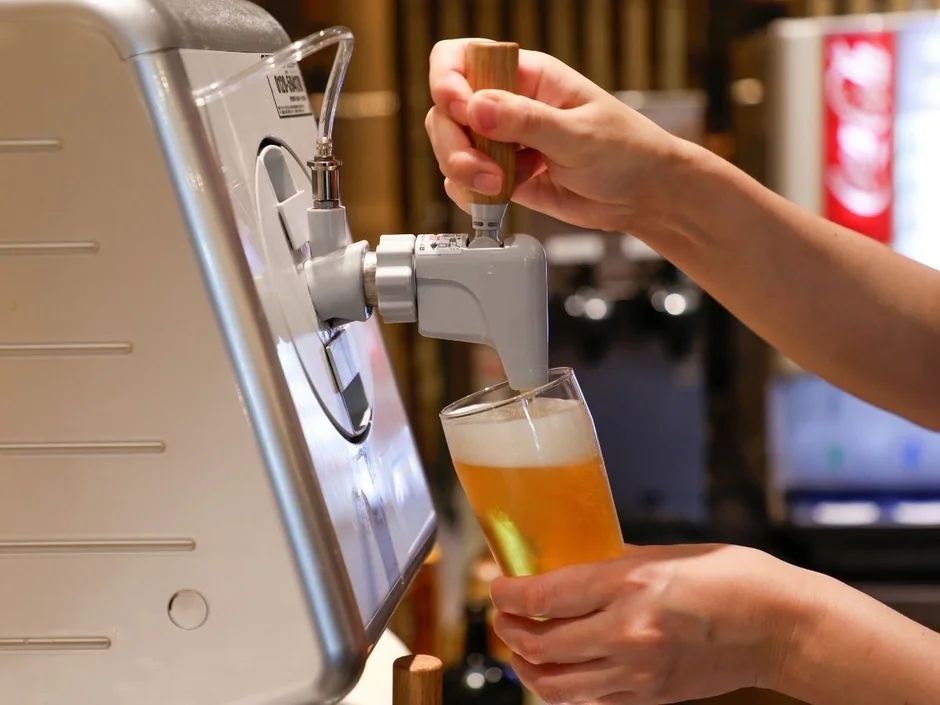 ビールディスペンサーでグラスにビールを注ぐ様子