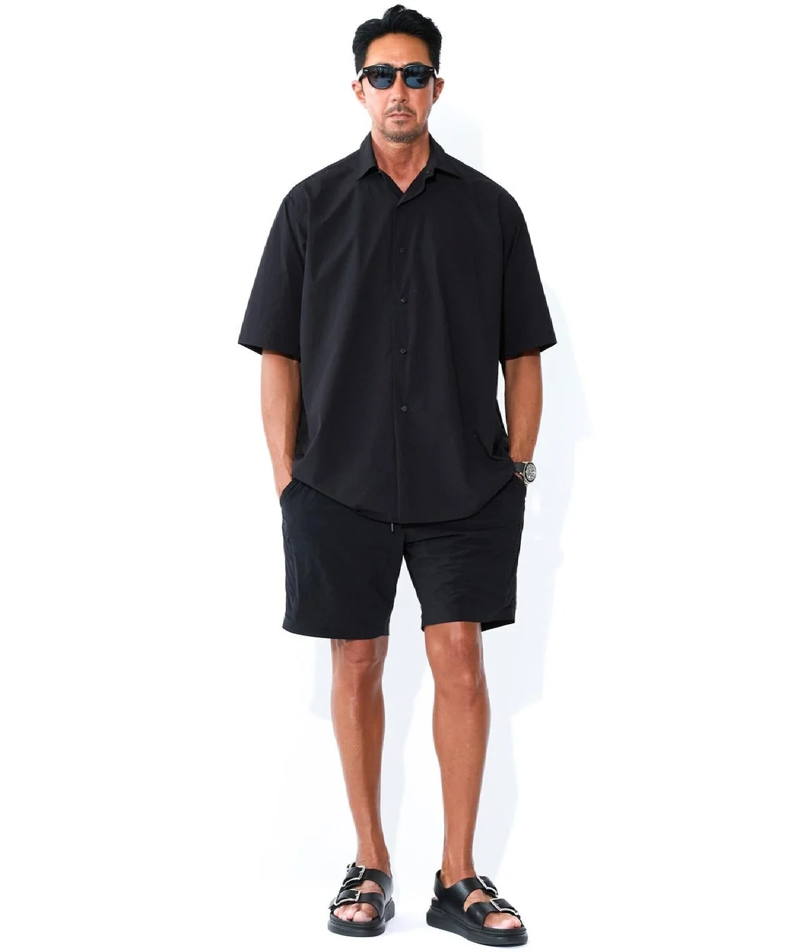 黒い半袖シャツとショートパンツを着用した男性