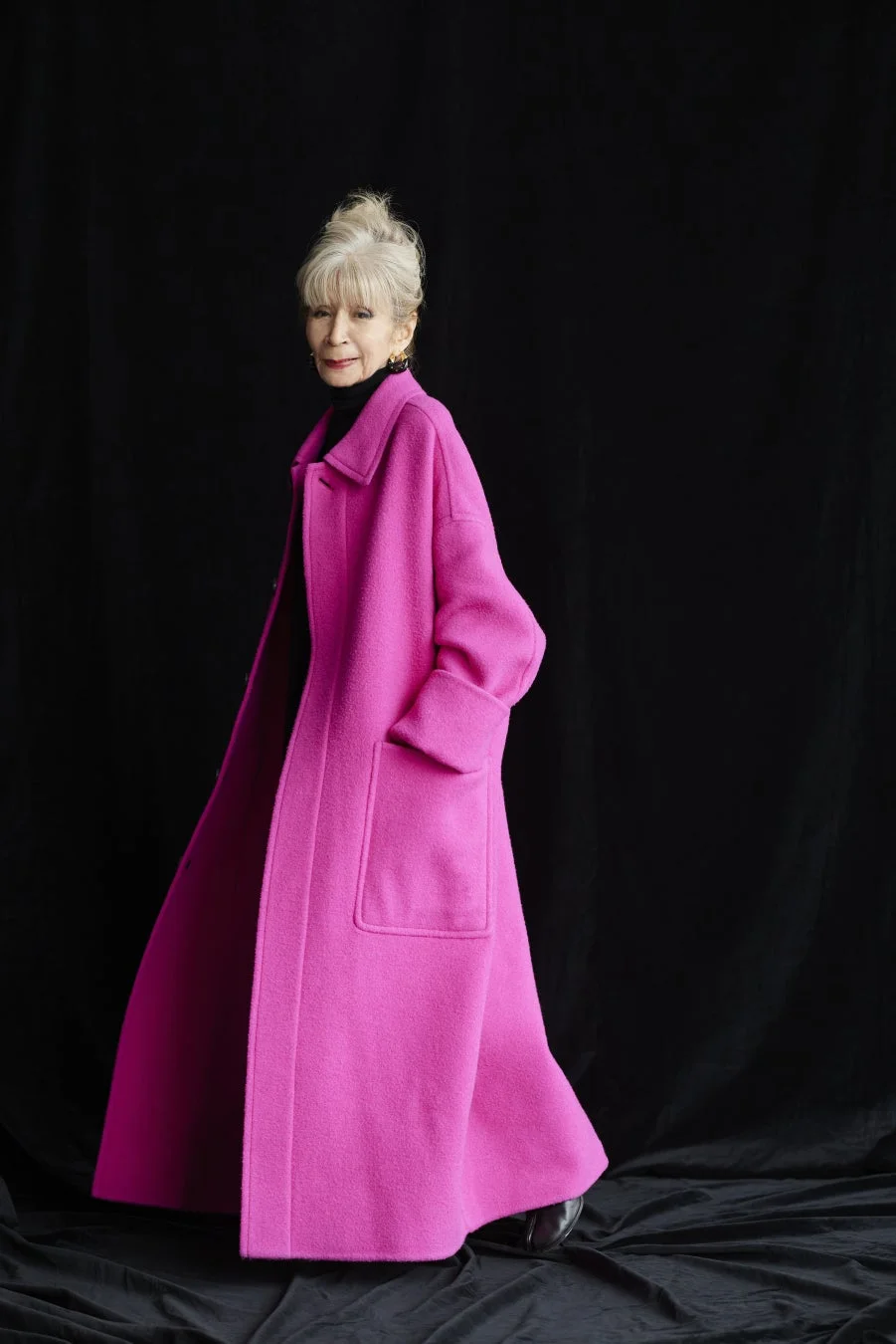 ピンクのコートを着用した川邉サチコ氏のポートレート