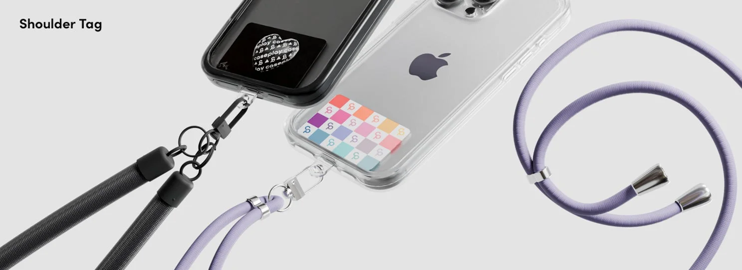 ブラックとクリアの2つのスマートフォンが、それぞれ異なる色のショルダーストラップに装着されている様子です。ハンズフリーでスマートフォンを持ち運べるアクセサリーが強調されており、機能性とデザイン性を兼ね備えています。