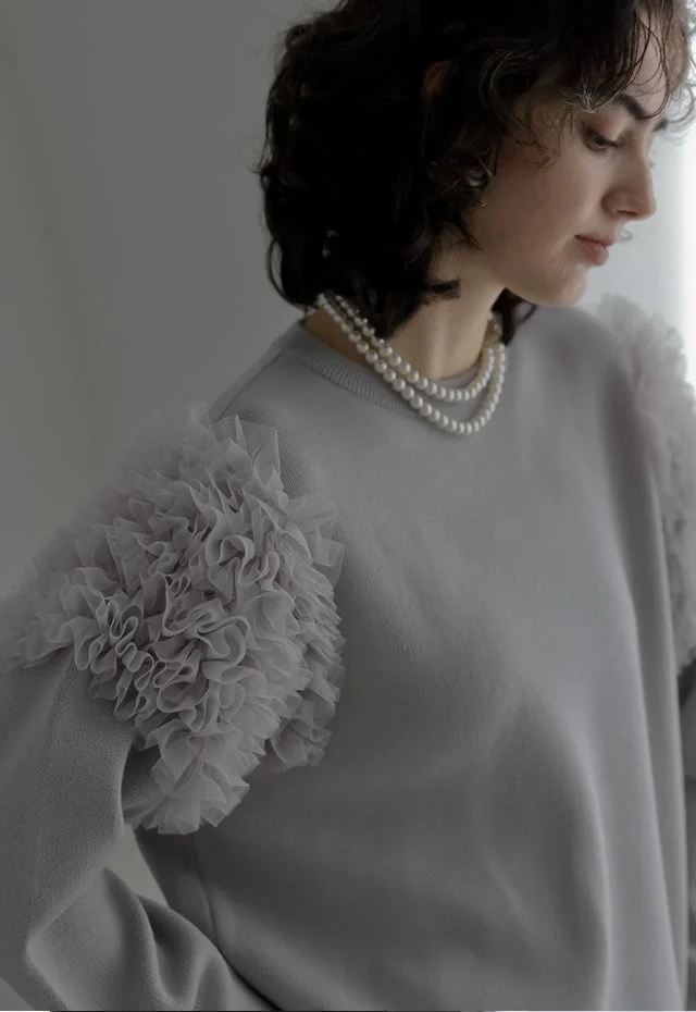 フリル袖グレーセーターとパールネックレスのポートレート