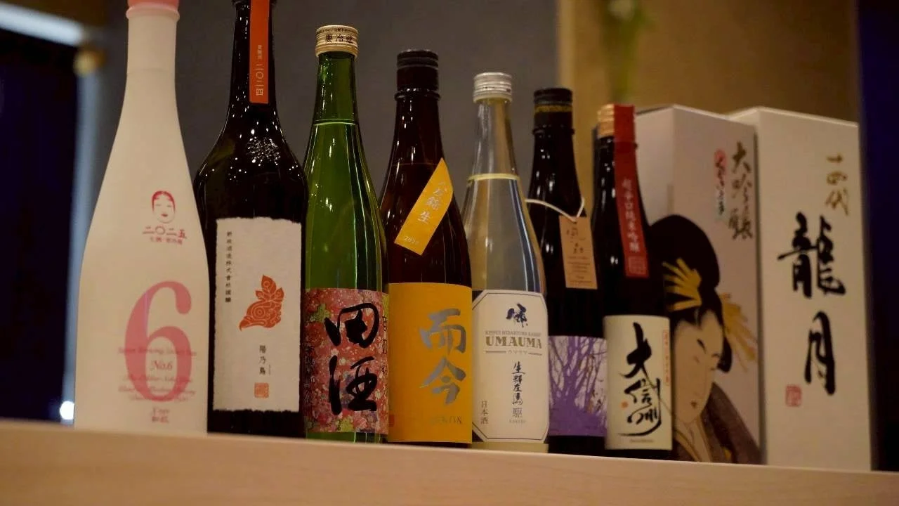 様々な銘柄の日本酒のボトルが棚に整然と並べられている様子