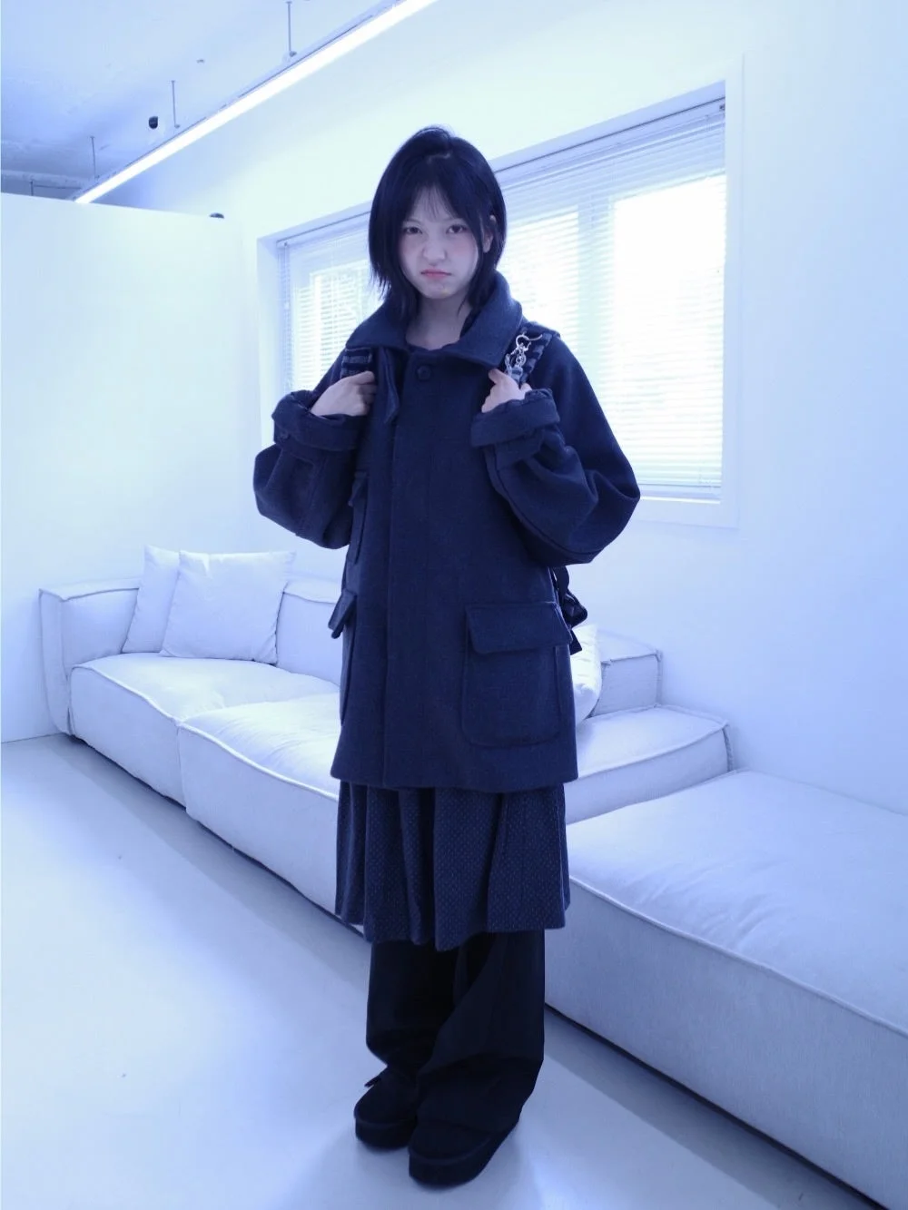 コートとバックパックを身につけた若い女性