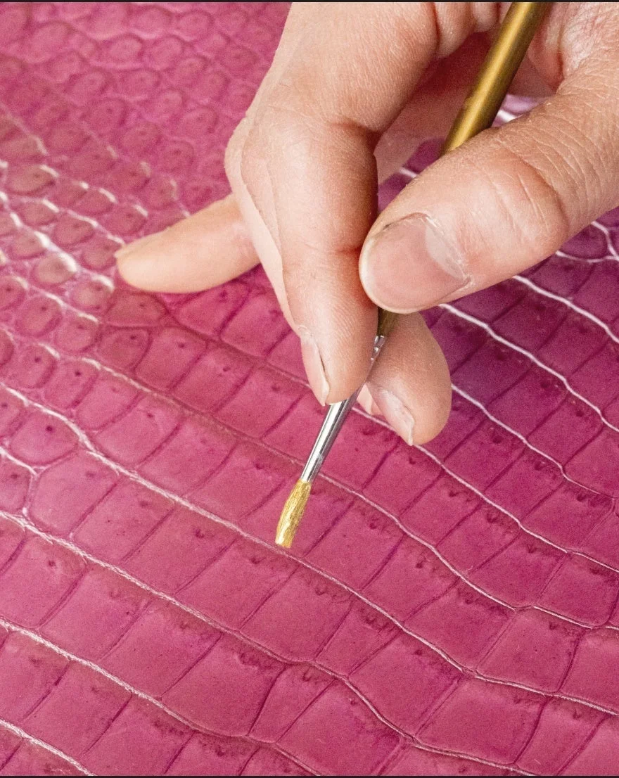 金色の絵の具で細部を塗る作業