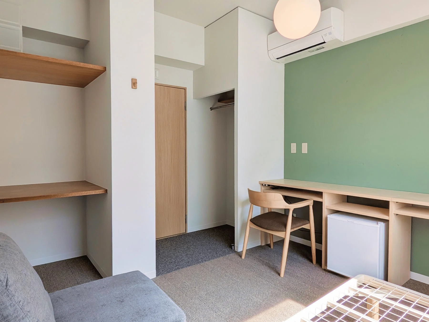 緑のアクセントウォールがある客室