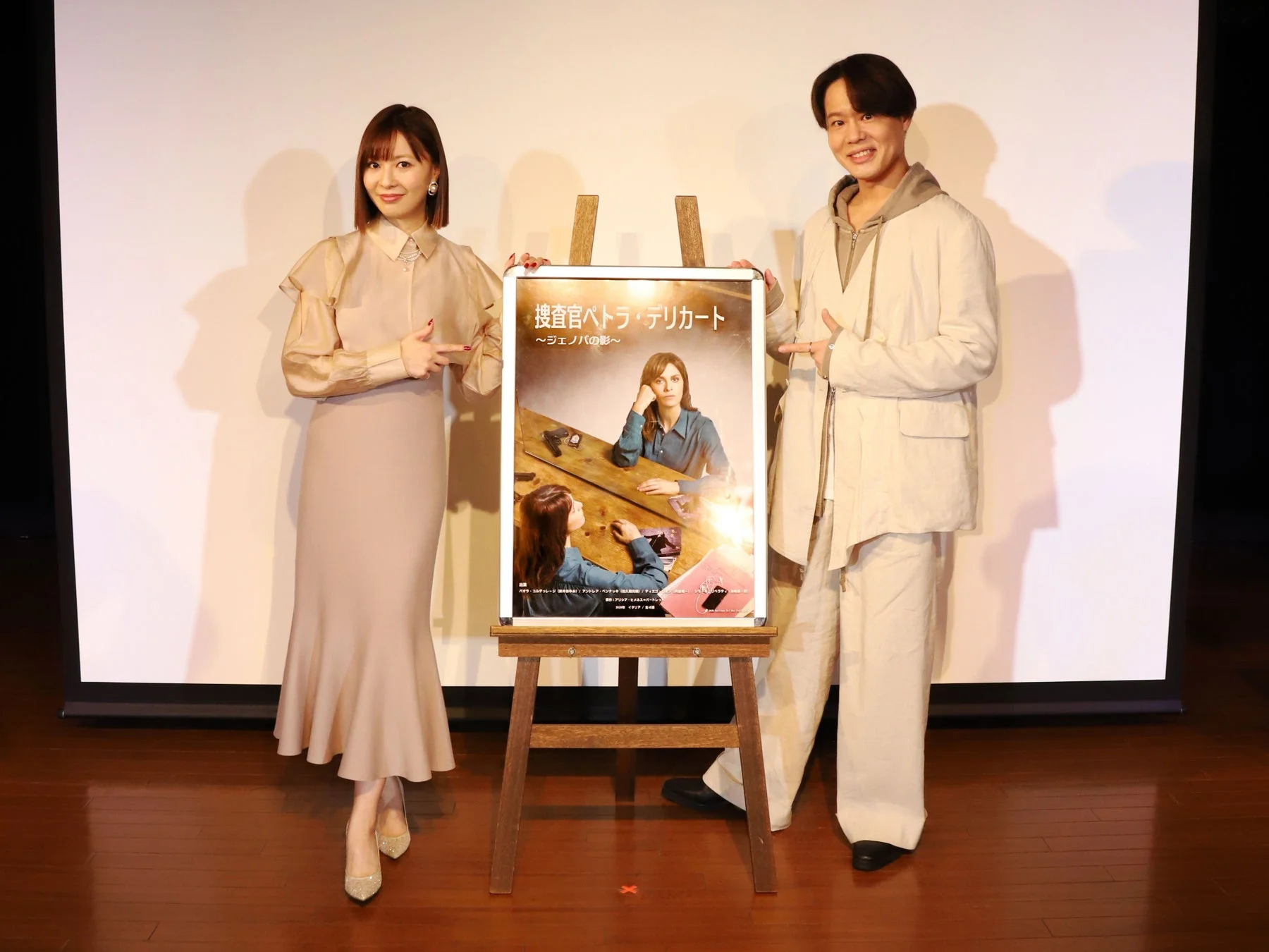 映画ポスターを挟んで男女の芸能人が笑顔でポーズをとるイベントの様子