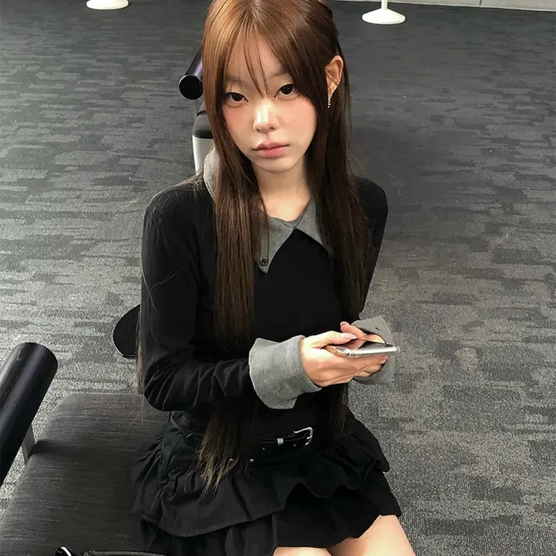 黒いトップスとスカートを着た若い女性が座ってスマートフォンを持つ