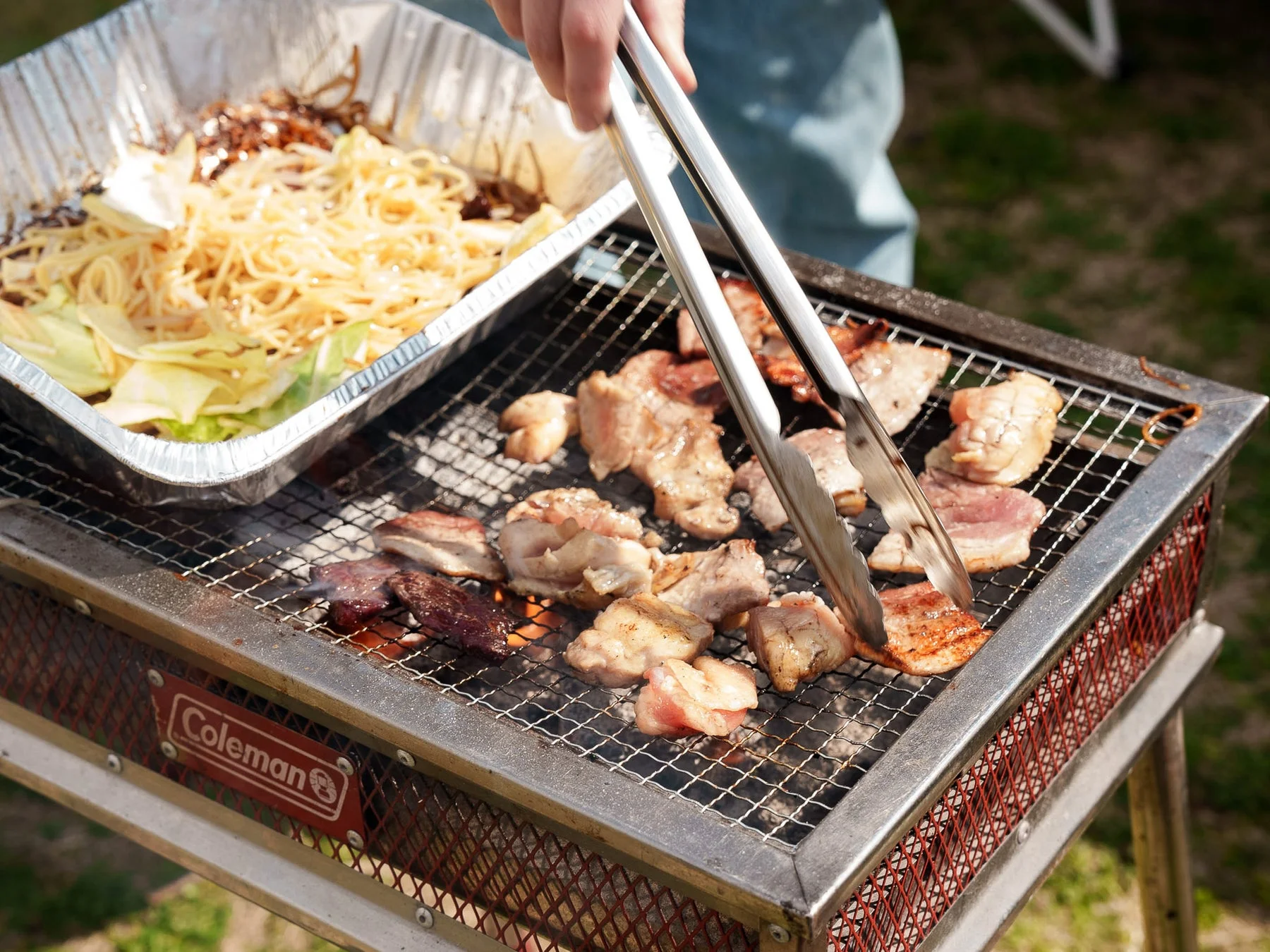 Coleman製グリルで肉を焼いている様子