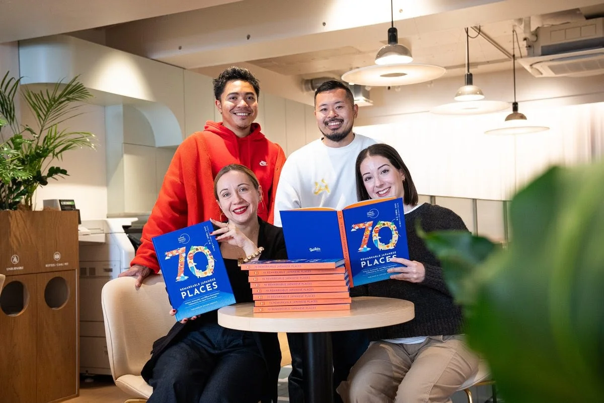 ジャパントラベルアワードのメンバーが本を持つ様子