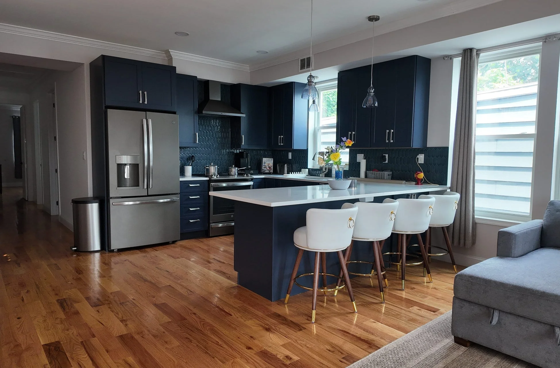 ダークブルーのモダンなキャビネットとステンレス製の大型冷蔵庫が目を引く広々としたキッチン