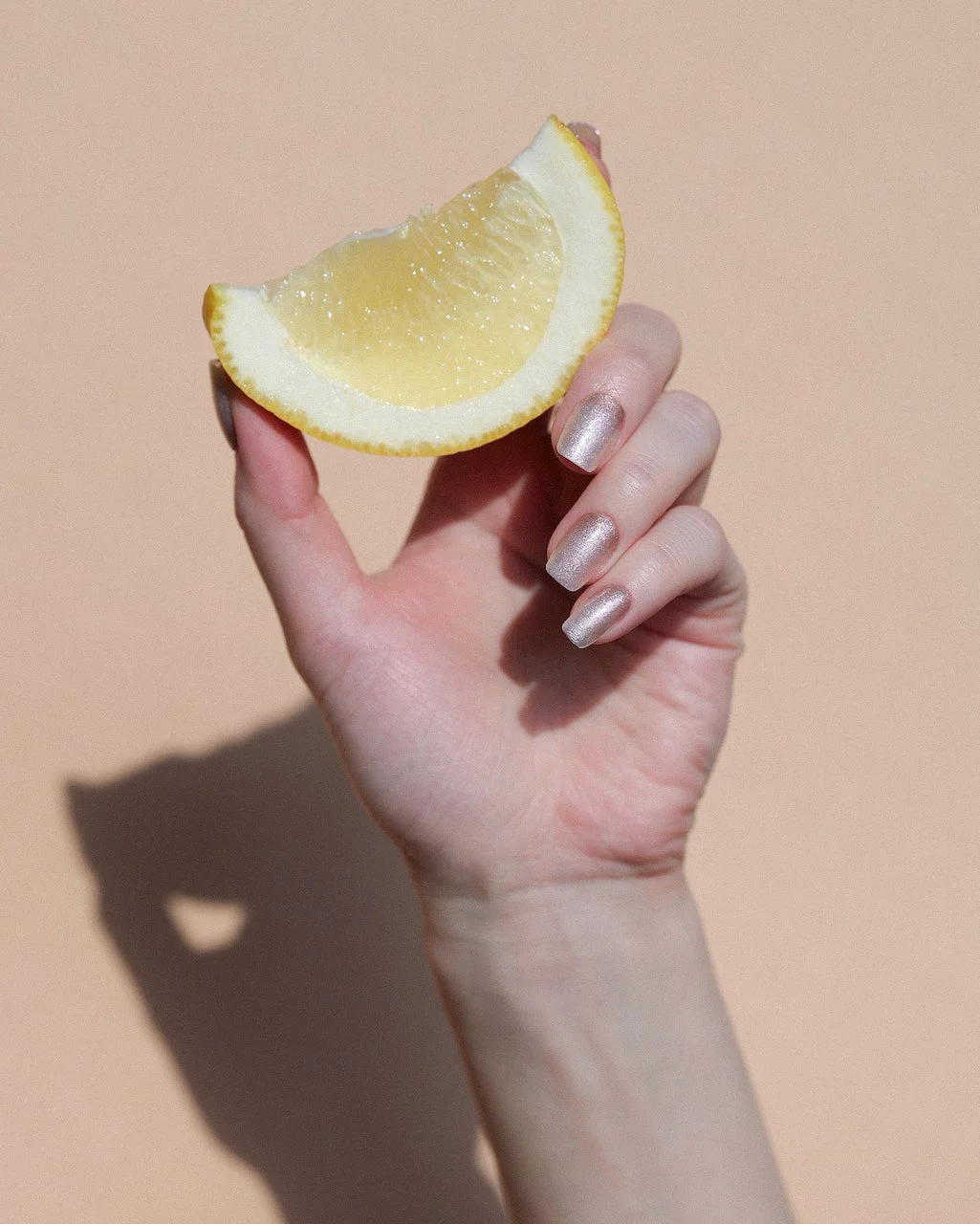 レモンを持つ手元のネイルアレンジ
