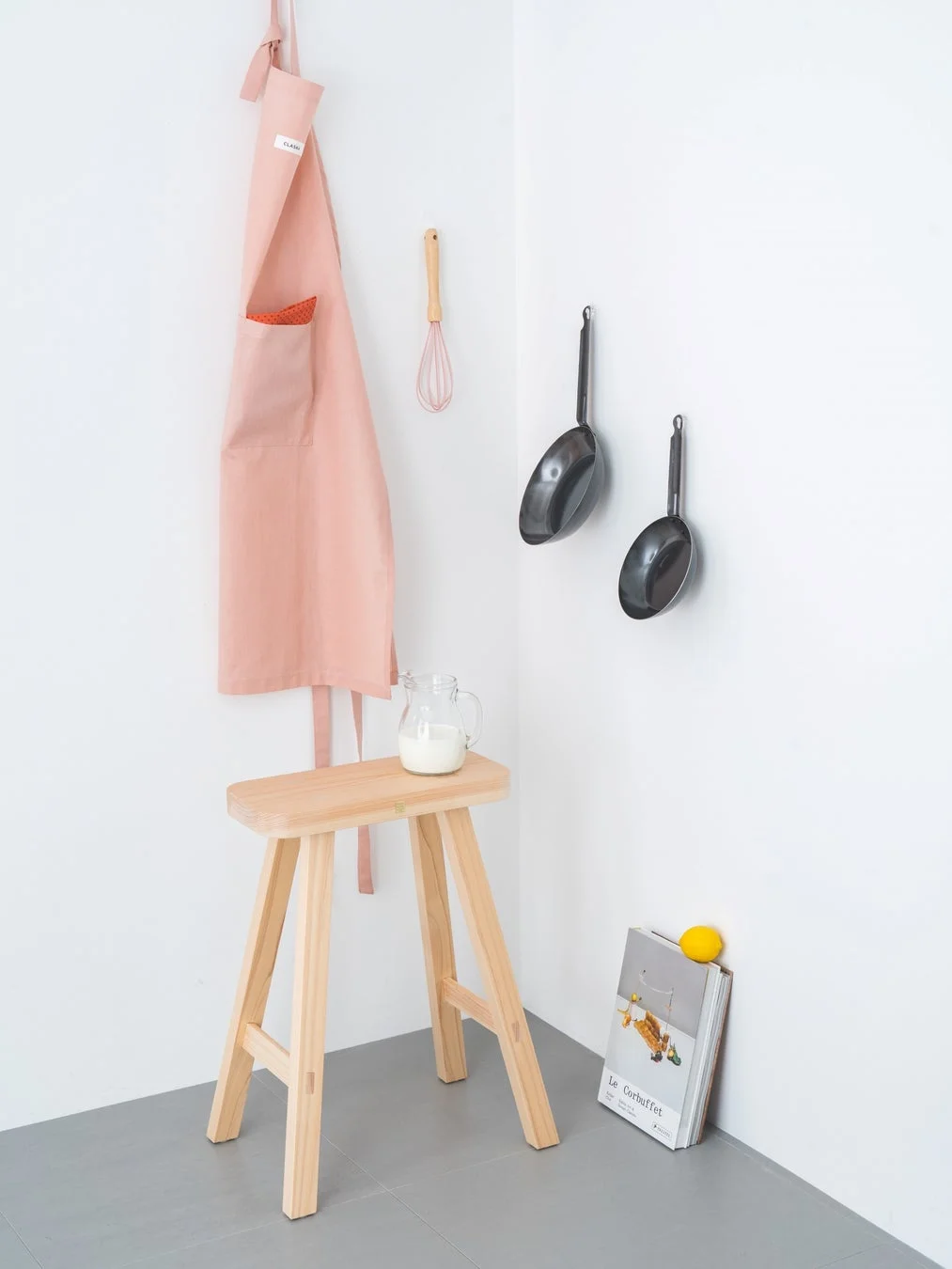 キッチンでエプロンや調理器具と共に置かれたスツール