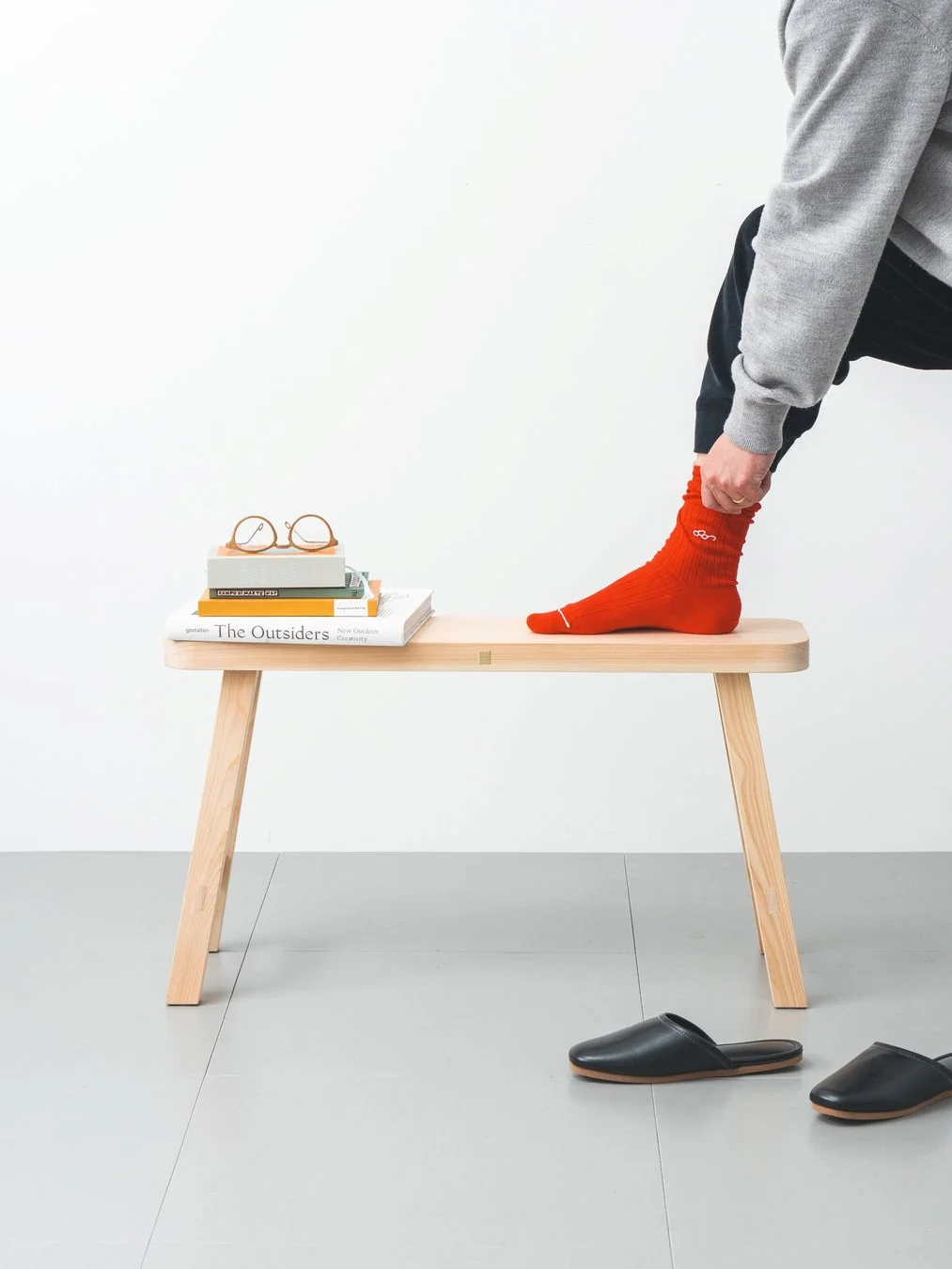 赤い靴下を履いた人が座っているベンチ