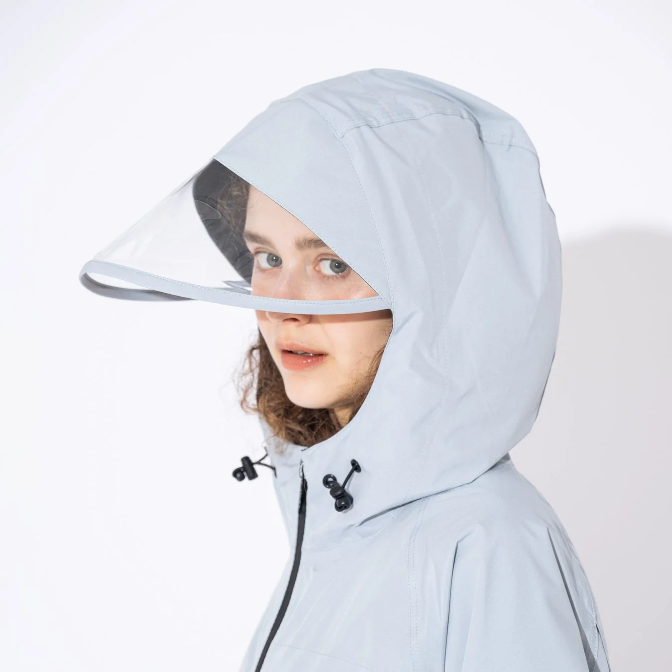 フードにクリアバイザーが付いたレインコート