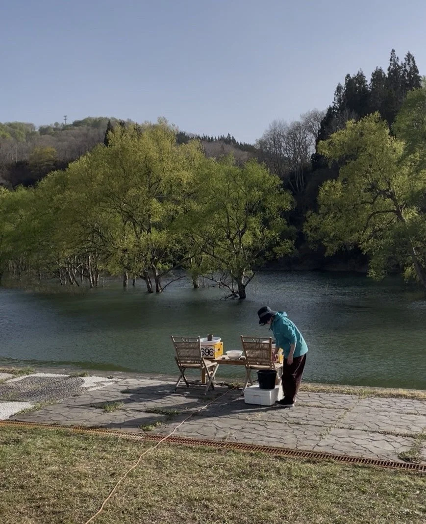 湖畔で一人の人物が準備をしている様子