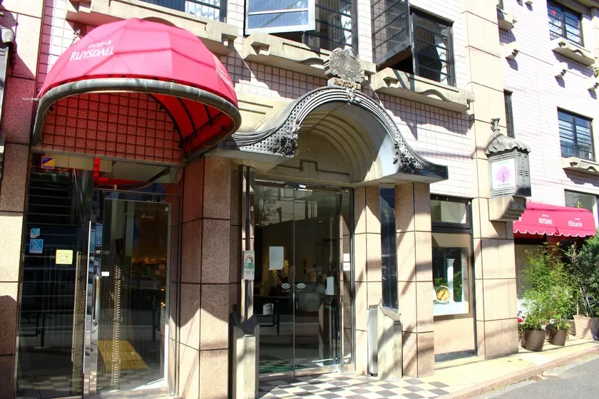 赤いひさしが特徴的な「RUISDAEL」という名前のパティスリーの店舗外観