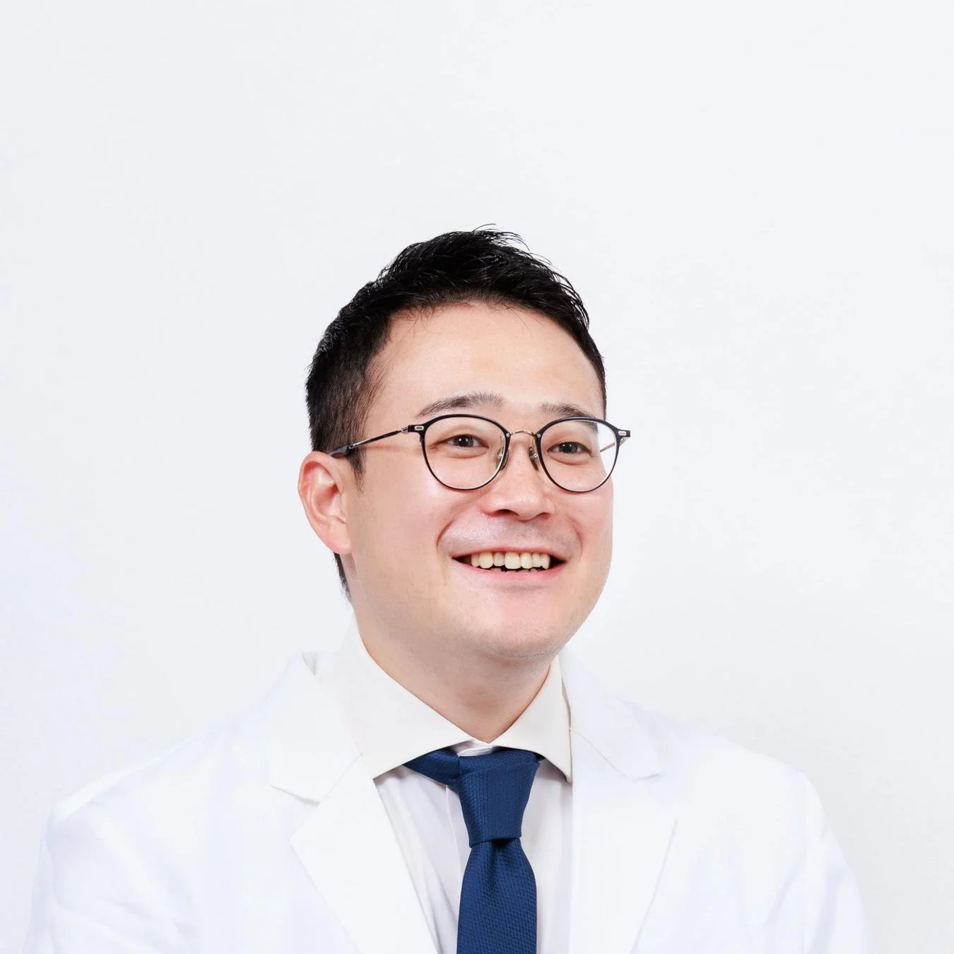 白衣を着て笑顔を見せる医療法人社団DMH 副理事長 辛島史憲先生