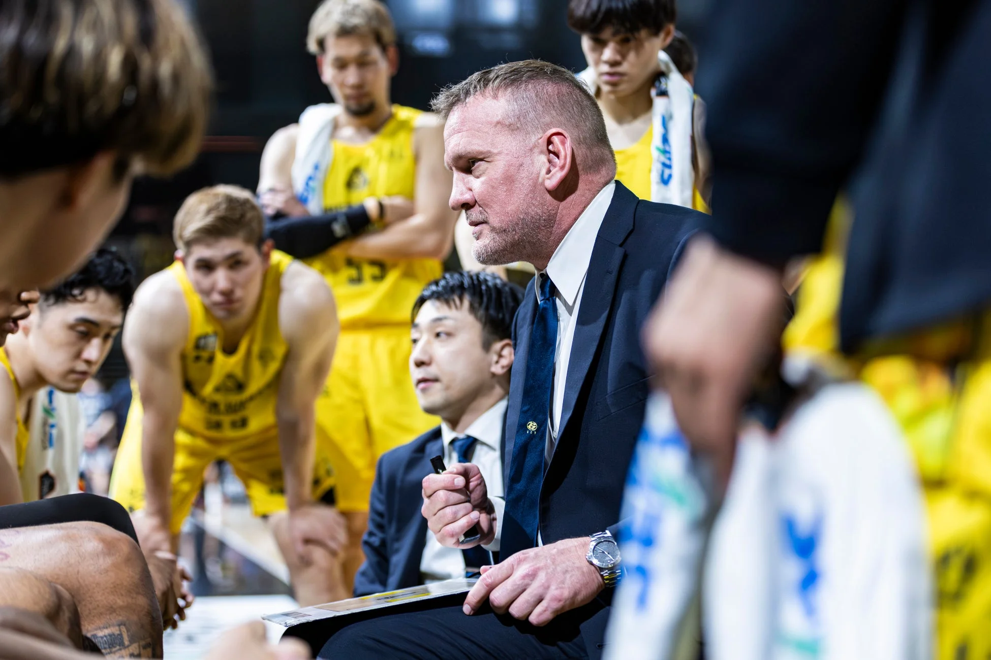 バスケットボールの試合中、コーチが選手たちに指示を与えている様子。