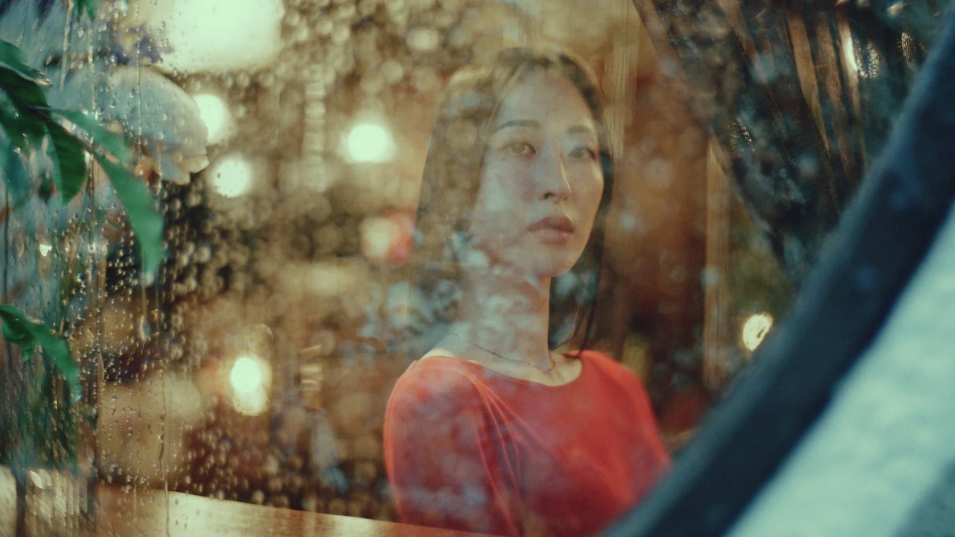 雨の窓を眺める後輩