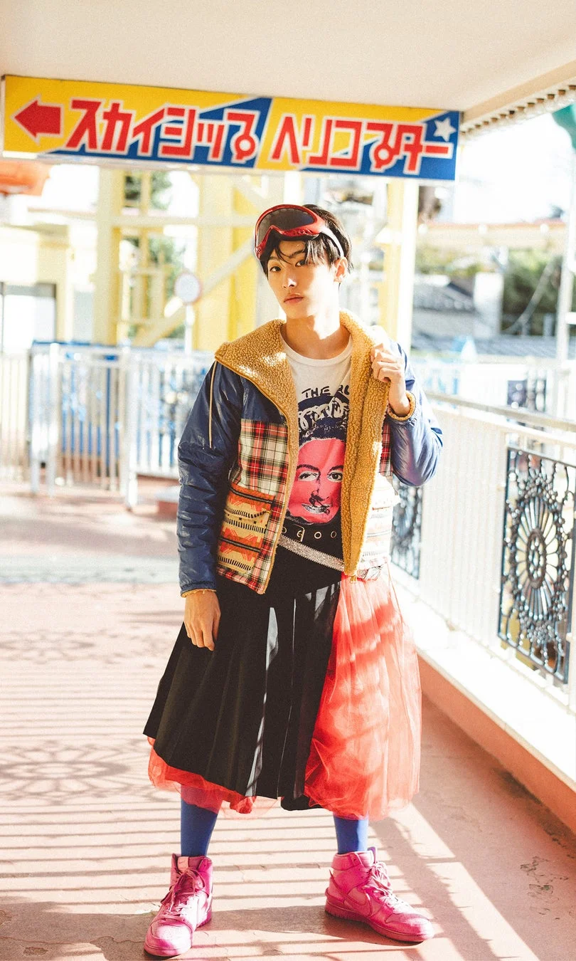 遊園地で個性的なファッションに身を包んだ若い男性