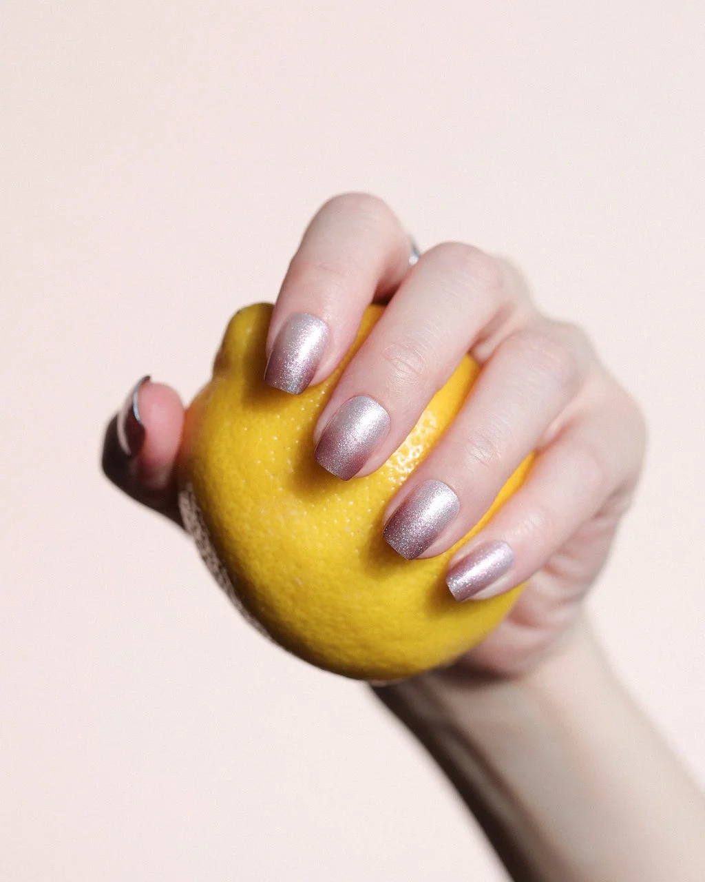 レモンを握る手元のネイルアレンジ