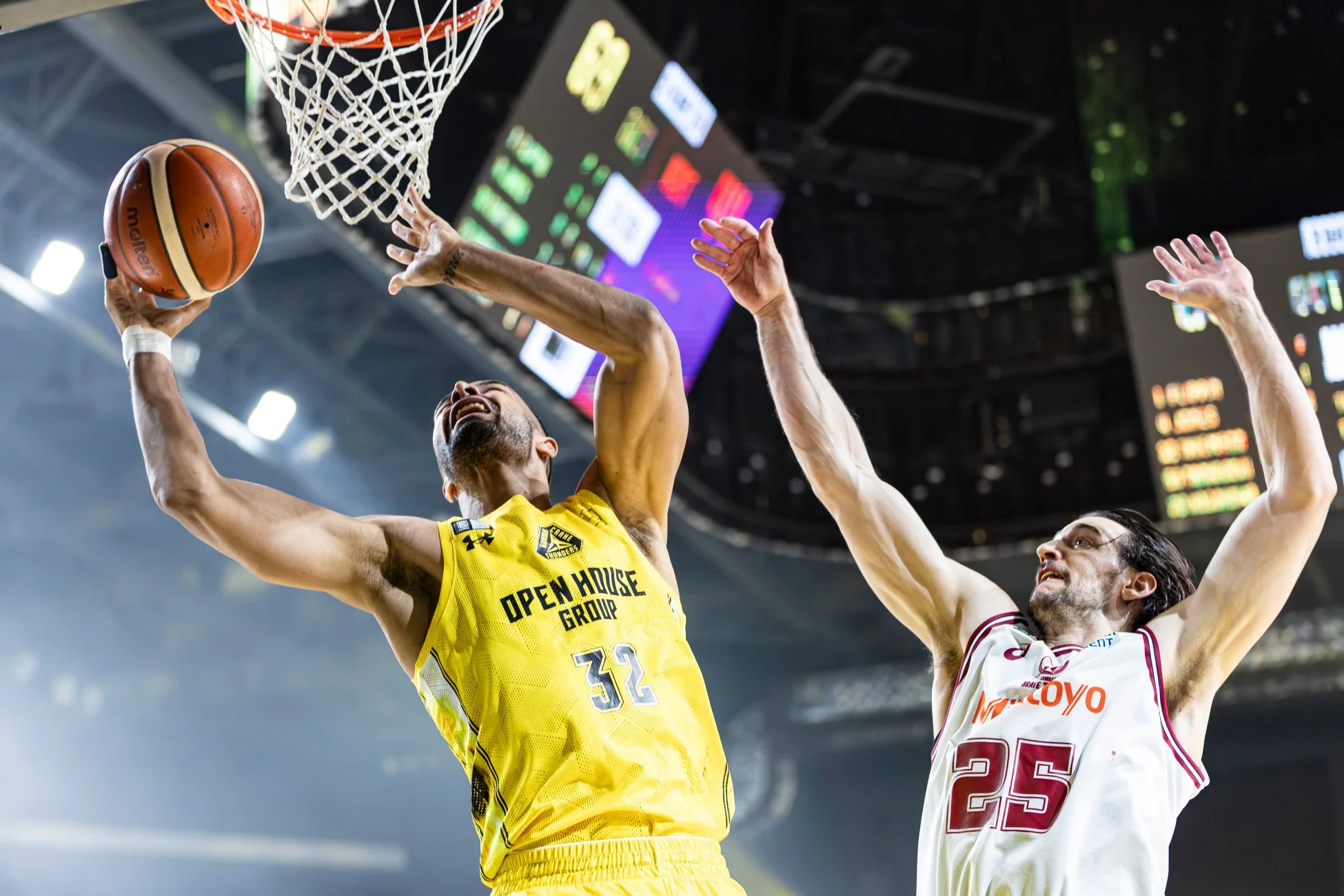 黄色のユニフォームを着た選手がシュートを放ち、白のユニフォームを着た相手選手がブロックしようとしている瞬間