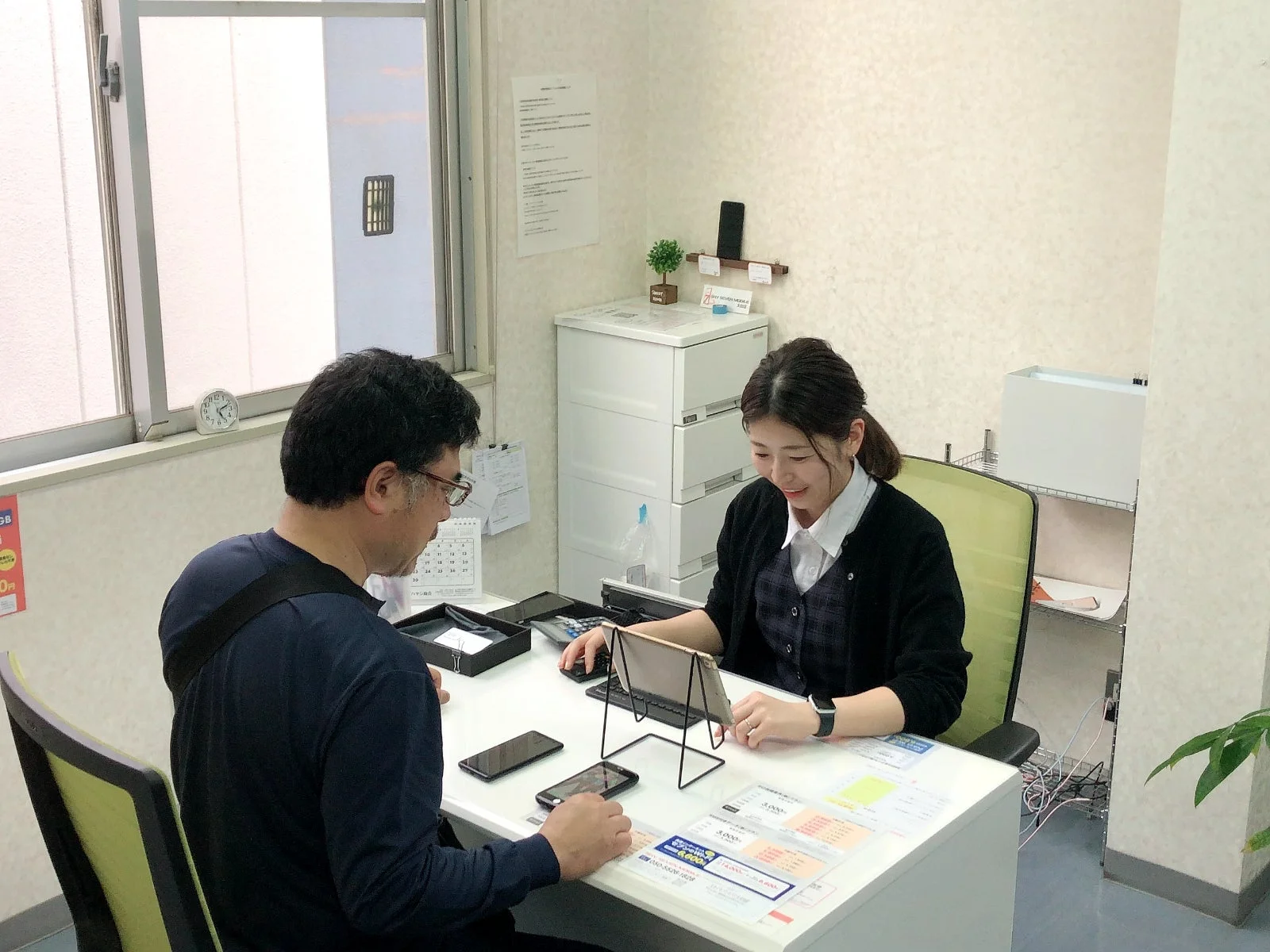 女性スタッフが男性客に説明する様子