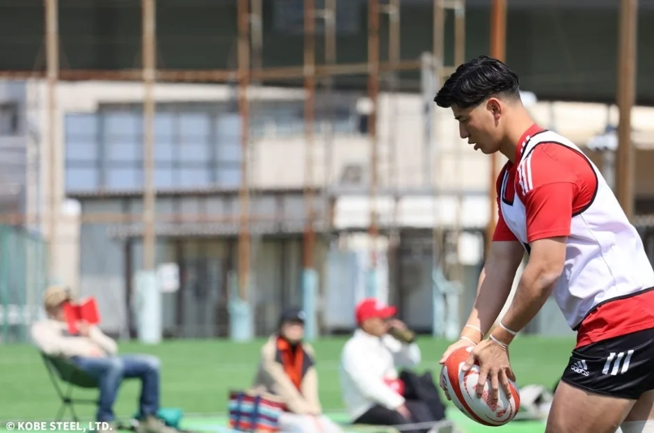 ラグビー選手がグラウンドでボールをセットし、キックの準備をしている